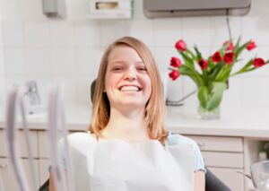 Happy patient smiling in a dental chair at Twin Oaks Dental Studio in Twin Oaks, MO, after a routine check-up with Dr. Clark.