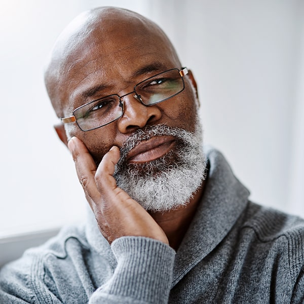 Senior man touching jaw with tooth pain, representing treatment for dental discomfort in Valley Park MO